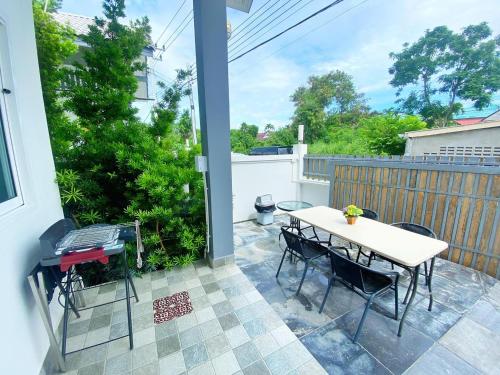 a patio with a table and chairs and a fence at Origin hua hin poolvilla in Hua Hin