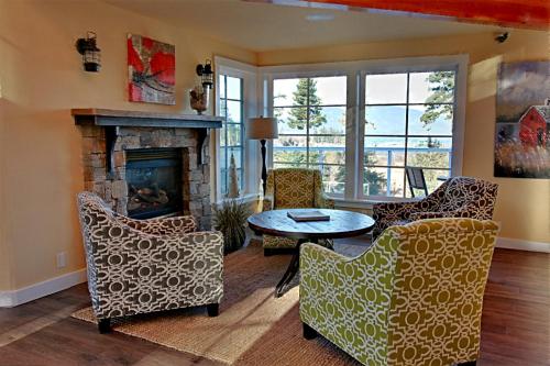 a living room with a fireplace and a table and chairs at Anacortes Ship Harbor Inn in Anacortes