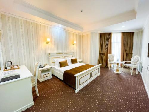 a hotel room with a large bed and a desk at Premier Palace Baku in Baku