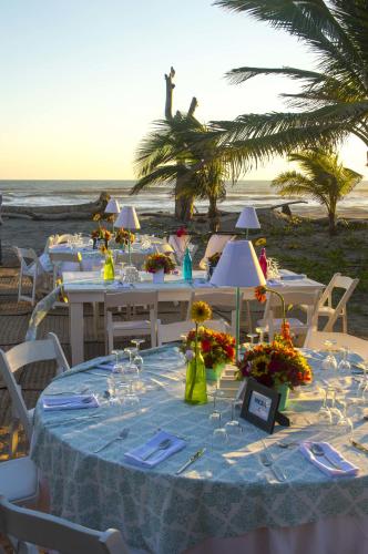 a table with a blue table cloth and flowers on a beach at Bambuddha Centro Holistico in Barra Vieja