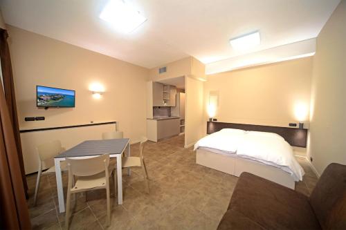 Schlafzimmer mit einem Bett, einem Tisch und Stühlen in der Unterkunft Smeraldo apartments in Sirmione