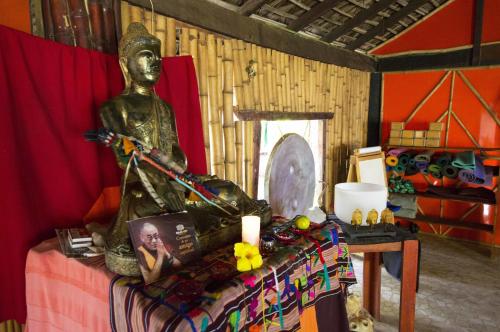 a statue sitting on a bed in a room at Bambuddha Centro Holistico in Barra Vieja
