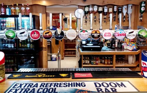 a bar with a bunch of stickers on the wall at Harry's Hotel & Restaurant in Aberystwyth