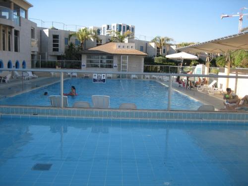 a large swimming pool with a person in the water at Nomi Suites Marina Herzelia in Herzelia 