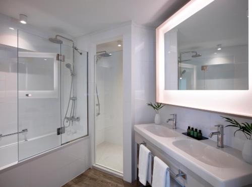 a bathroom with a sink and a shower and a mirror at Rhodes Bay Hotel & Spa in Ixia