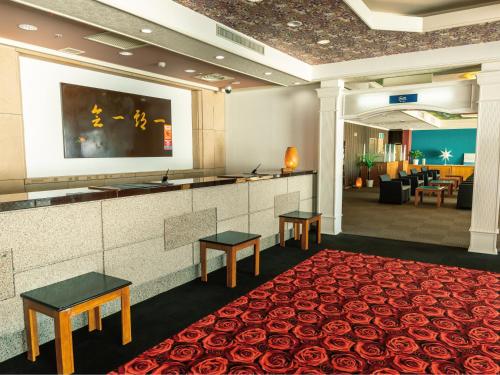a hotel lobby with a red carpet and a bar at Atagawa Onsen Blue Ocean in Higashiizu