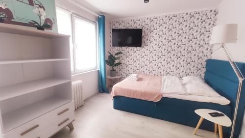 ein kleines Schlafzimmer mit einem blauen Bett und einem Fenster in der Unterkunft Na Szaniec 17 by Homeprime in Krakau