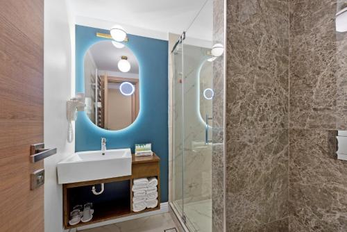 a bathroom with a sink and a shower at Hotel Oxford in Mamaia