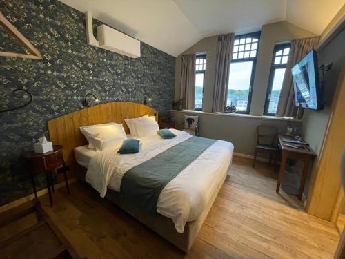 a bedroom with a bed and a television in it at Hôtel Maison Demelenne in Hotton