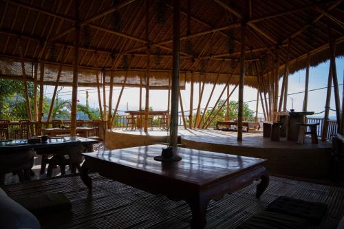艾湄灣的住宿－Aroma De La Mer，一间设有桌子和大型稻草屋顶的客房