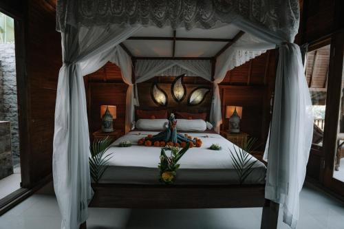 a bedroom with a bed with a canopy at Aroma De La Mer in Amed