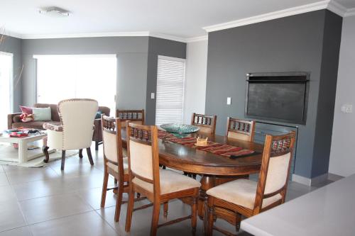 a dining room with a table and chairs and a tv at Atlantic Dunes Unit 11, Self Catering in Rand Rifles