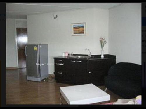 sala de estar con sofá y nevera en Thailand Taxi Apartment Hostel, en Thung Si Kan