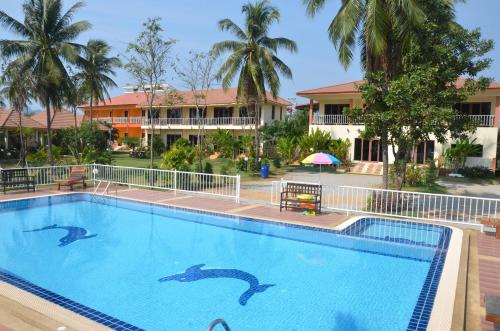 a swimming pool at a resort with dolphins in the water at Pranmanee Beach Resort in Sam Roi Yot