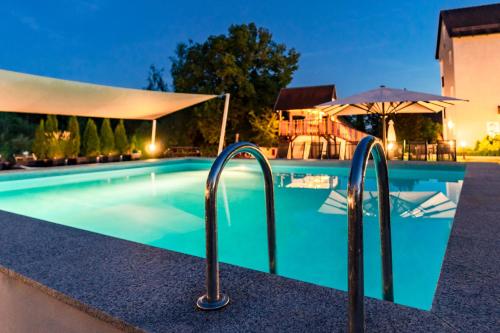 ein Schwimmbad in der Nacht mit einem Resort in der Unterkunft Familienhotel Friedrichshof in Obertrubach