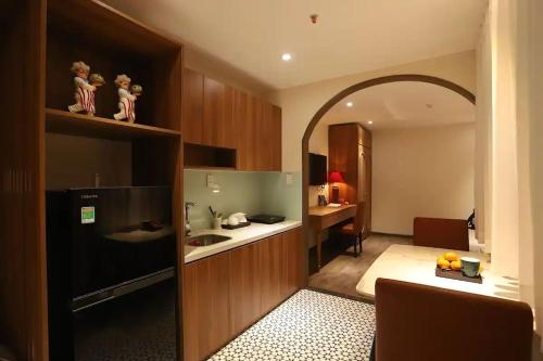 a room with a kitchen with a sink and a desk at Lanura Apartments and Hotel in Ho Chi Minh City