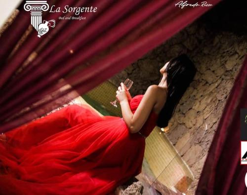 a woman in a red dress sitting on the ground at B&B La Sorgente in Brindisi