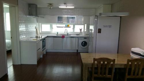 a kitchen with a sink and a refrigerator and a table at Aquarius Building I 2043 in Geoje 