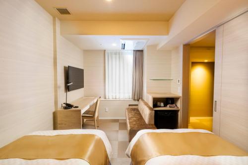 a hotel room with two beds and a television at Best Western Hotel Fino Tokyo Akasaka in Tokyo