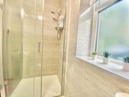 a shower with a glass door in a bathroom at Tong Apartments in Leeds