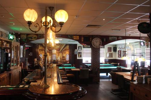 a bar in a pub with tables and pool tables at Hotel,cafe,biljart POT in Groenlo