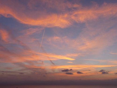 a plane is flying in the sky at sunset at Think Love on Red Sea in Nuweiba