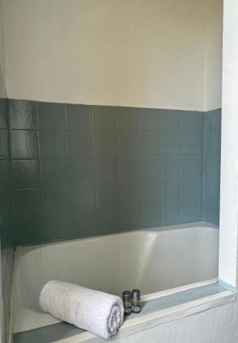 a bathroom with a bath tub with a towel on it at HOTEL KAN AVEL in Saint-Lunaire