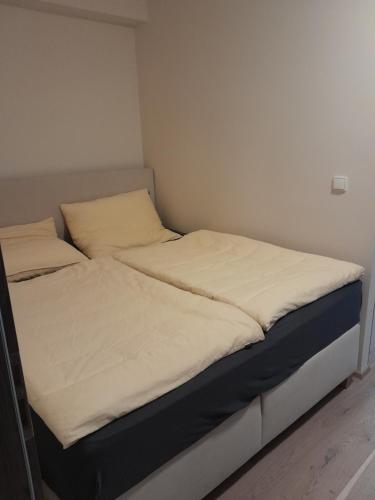 uma cama com lençóis brancos e almofadas em Apartmán pod Jasanem Hojsova Stráž Brčálník em Železná Ruda