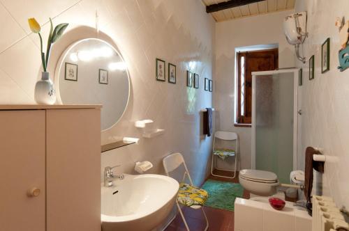 ein Badezimmer mit einem Waschbecken, einem WC und einem Spiegel in der Unterkunft Geranio Rosso in Pergusa