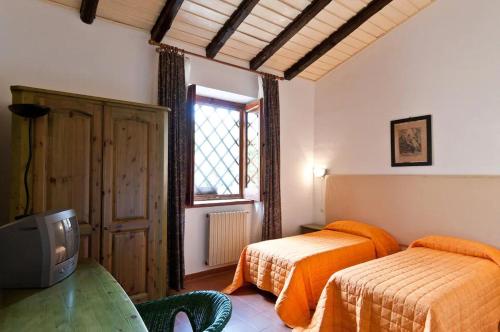 1 Schlafzimmer mit 2 Betten, einem TV und einem Fenster in der Unterkunft Geranio Rosso in Pergusa