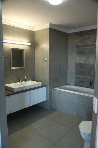 a bathroom with a sink and a tub and a toilet at Atlantic Dunes Unit 11, Self Catering in Rand Rifles