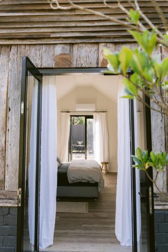 un dormitorio en una casa con una cama en ella en Redwood Park - Luxury Off Grid Accommodation, en Wollombi