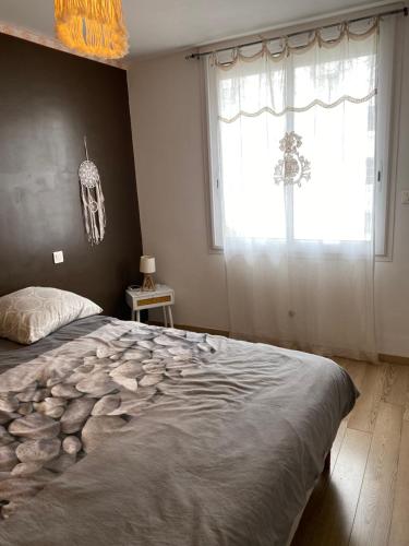 une chambre avec un grand lit et une fenêtre dans l'établissement Cosy T2 avec terrasse à 5 min de la plage, à Sète