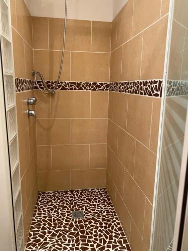 La salle de bains est pourvue d'une douche et de carrelage. dans l'établissement Cosy T2 avec terrasse à 5 min de la plage, à Sète