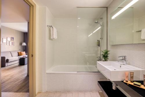 فندق سيتادينز رامبلاس برشلونة في برشلونة: حمام مع حوض أبيض ومغسلة