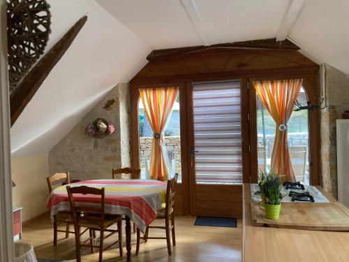 a dining room with a table and some windows at Domaine de Galoubet, Lot , Gîtes de charme in Beaumat
