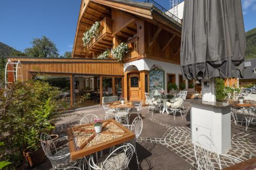 uma casa com um pátio com mesas e cadeiras em Hotel Lipa em Kranjska Gora