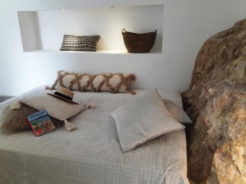 a bedroom with a bed with a large rock at Design Studio Cap Rubio Ibiza in Na Xamena