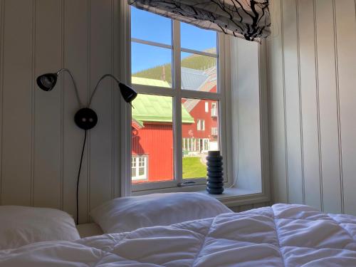 a bedroom with a bed and a window with a red building at Åre Travel - Åre Park in Åre