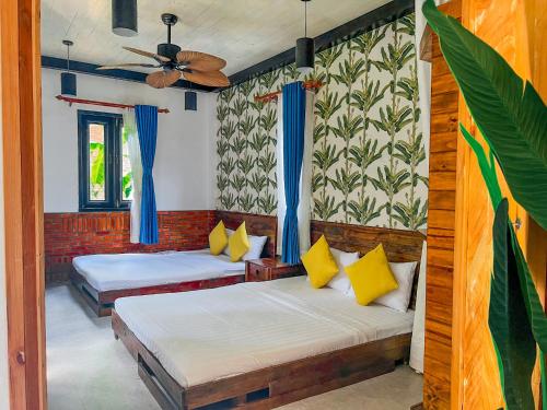 a bedroom with two beds and a ceiling fan at Long Hải Channel Beach Resort in Long Hai