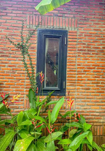 a window in a brick wall with plants in front of it at Long Hải Channel Beach Resort in Long Hai