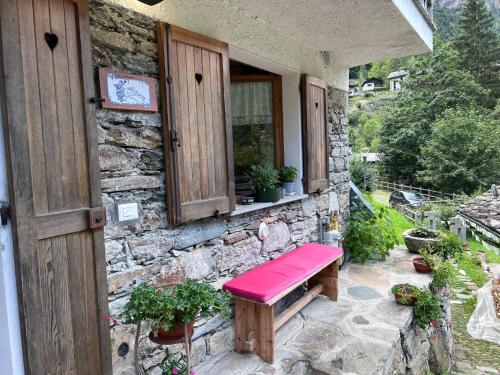 a bench sitting outside of a stone building at CASA NONNA RINA in Alagna Valsesia