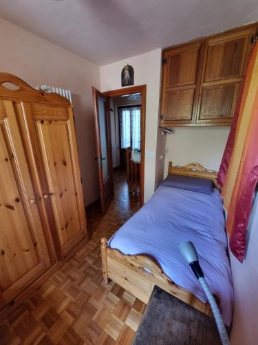 a bedroom with a bed and wooden cabinets at CASA NONNA RINA in Alagna Valsesia