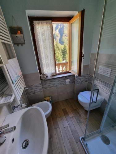 a bathroom with two sinks and a window in it at CASA NONNA RINA in Alagna Valsesia