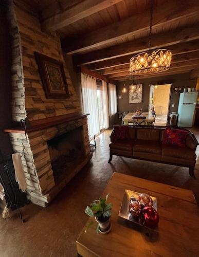 a living room with a couch and a fireplace at Beautiful Cabin Downtown Tapalpa Oven Mud Barbecue Grill 4 Room 12 ppl TV Wifi in Tapalpa