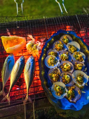 a grill with food on it with fish on it at Long Hải Channel Beach Resort in Long Hai