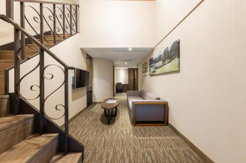 a living room with a couch and a table at Taoyuan Yuehua Hotel & Golf Club in Longtan