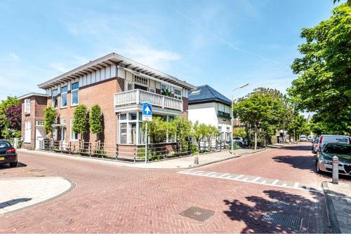 a brick building on a street with cars parked in front at Studio en deluxe appartement Blueberry in Zandvoort