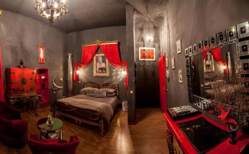 a bedroom with a bed with red curtains and a couch at Repubblica Di Oz Rooms in Varese