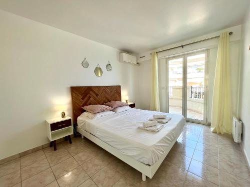 a bedroom with a large bed and a large window at "Le Victoria Beach" Vue Mer Plein Centre, Spacieux in Menton